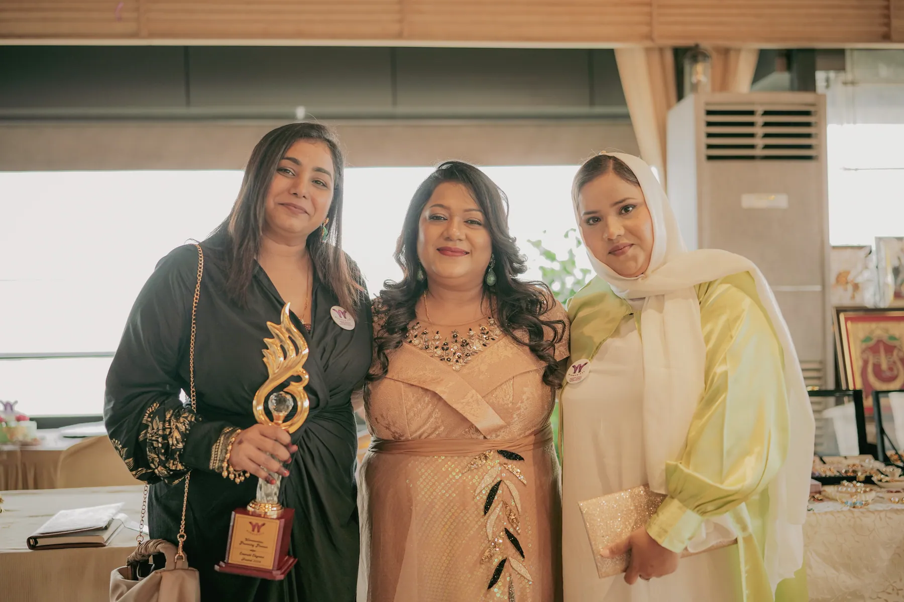 Sneha holding an award with fellow guests