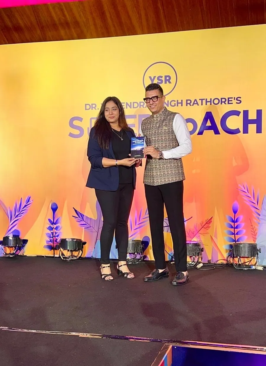 Sneha receiving recognition on stage
