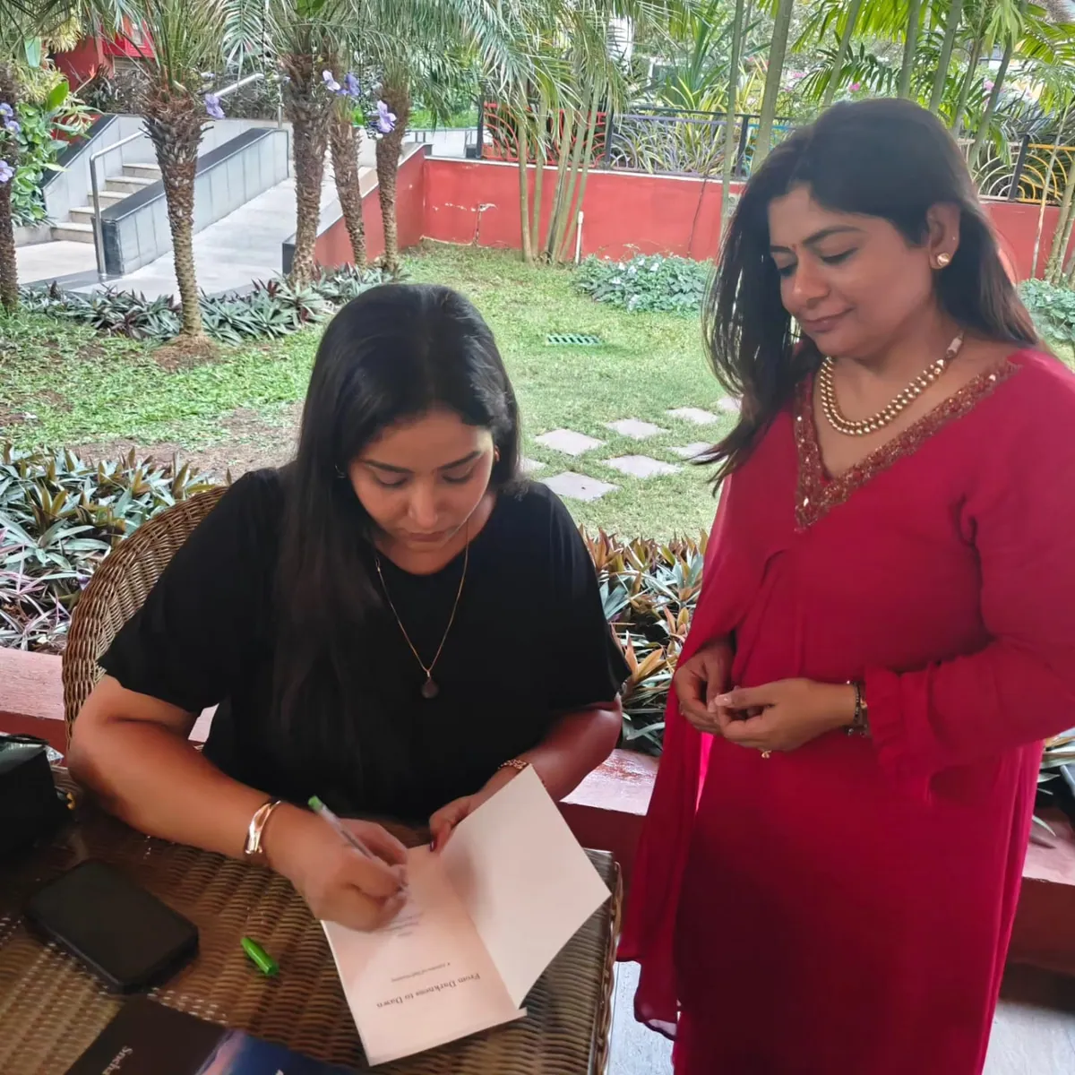 Sneha signing a copy of her book